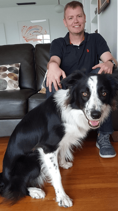 Dr. Richard Connolly seated at home with his dog.