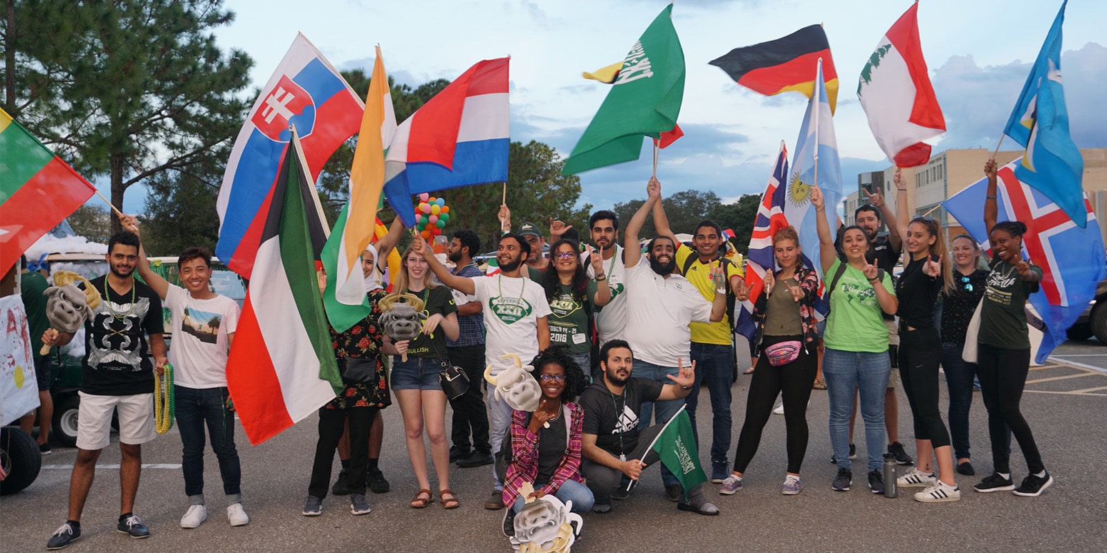 USF World students pose for a photo with the flags of various countries