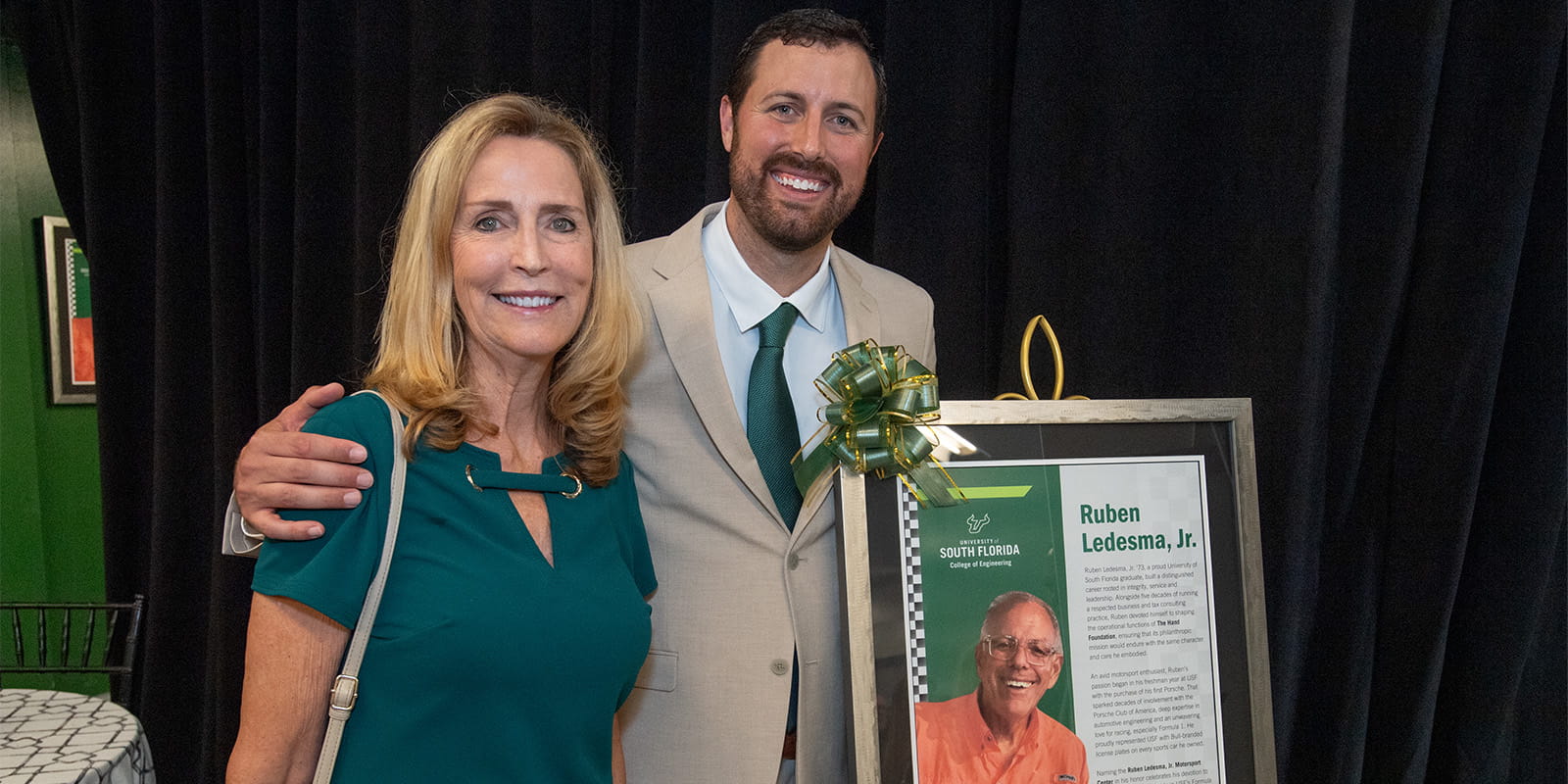 Wesley Ledesma and his mother, Janet, pose next to a photo of Ruben Ledesma Jr. at the celebration event